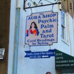 a sign on the side of a building that says aura shop psychic palm and tar