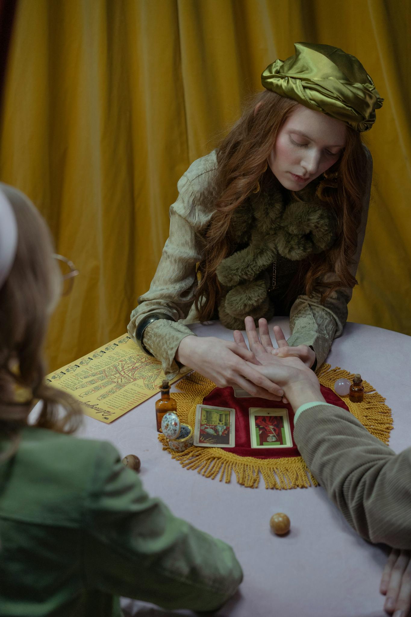 A fortune teller reads a palm surrounded by tarot cards, evoking a mystical atmosphere.