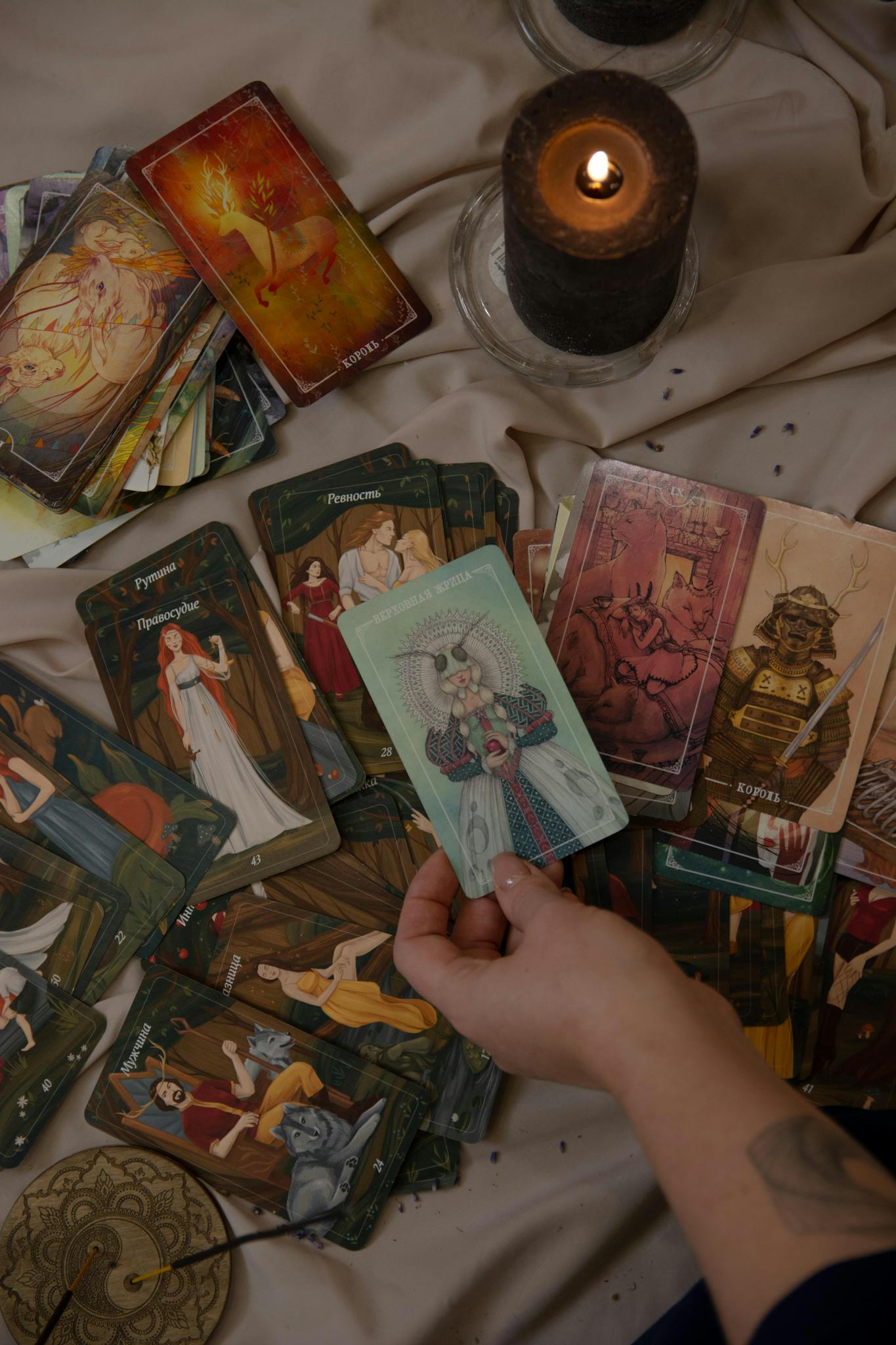 A person engaging in tarot card reading, surrounded by candles for a mystical atmosphere.