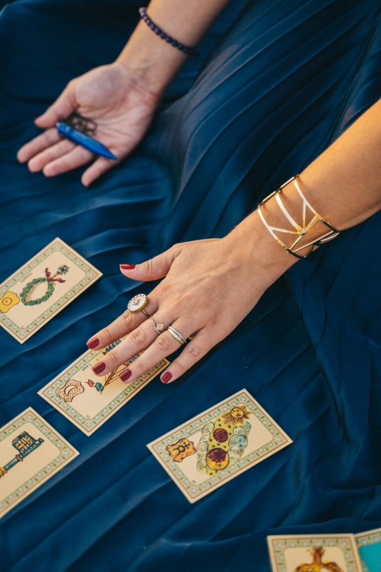 Elegant tarot card reading session with hands, jewelry, and mystical atmosphere.